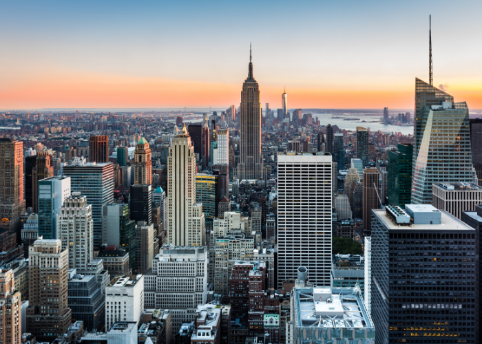 New york city skyscrapers against orange sunset.