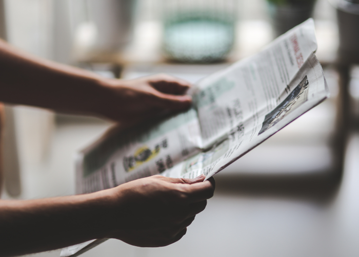 Person reading newspaper articles.