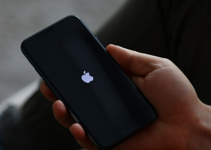 Person holding black iphone turning on or off.