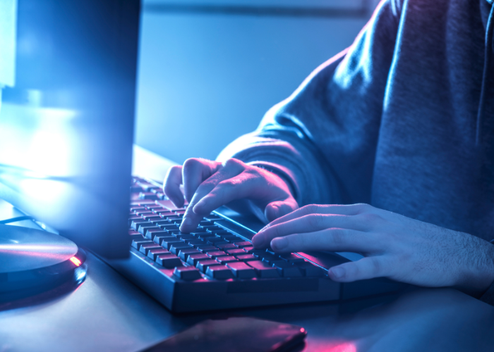 boy typing into lit up computer screen and keyboard.