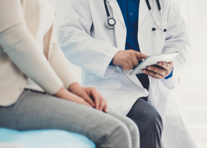 Doctor in lab coat explaining treatment to patient.