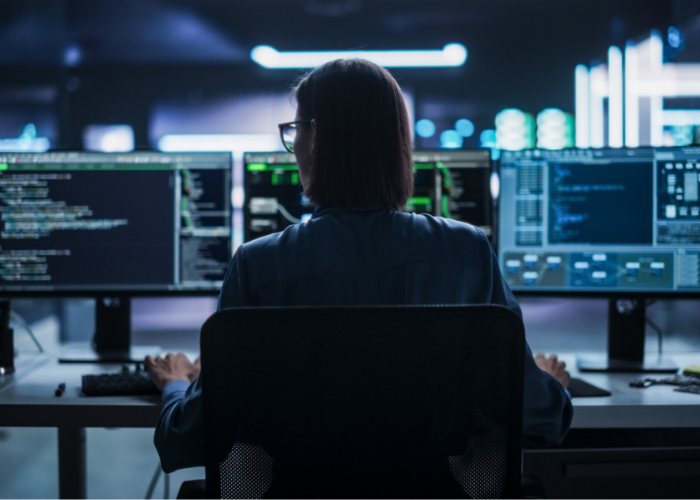 woman sitting at desk inputting computer data.
