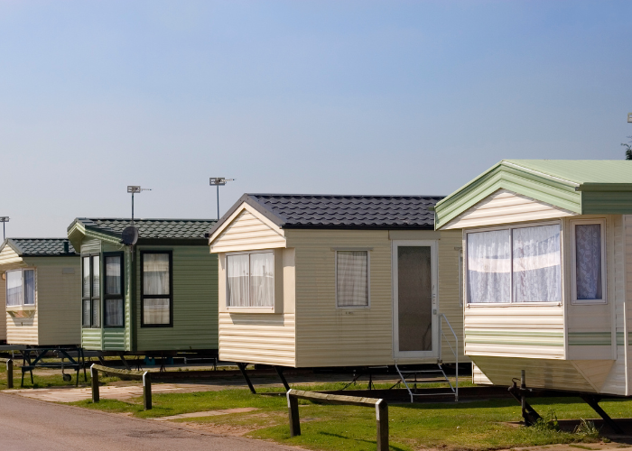 Multiple colored mobile homes sitting in lot.