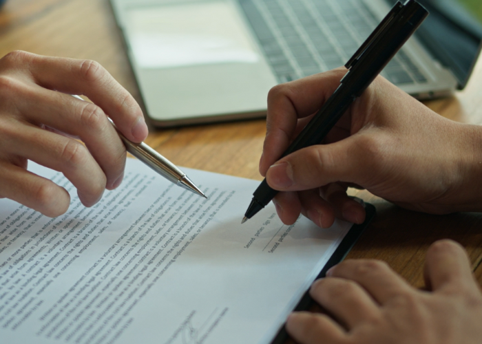 Sign a business contract with guidance from business man.