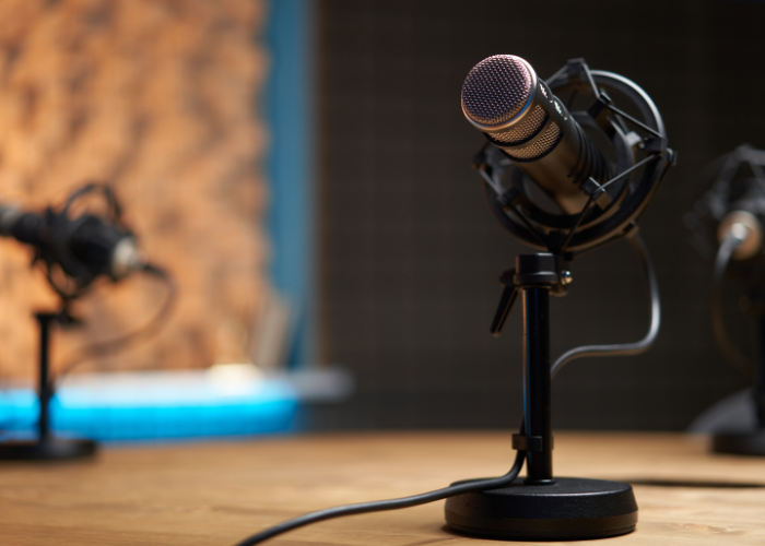 Podcast microphones on wooden table ready to record.