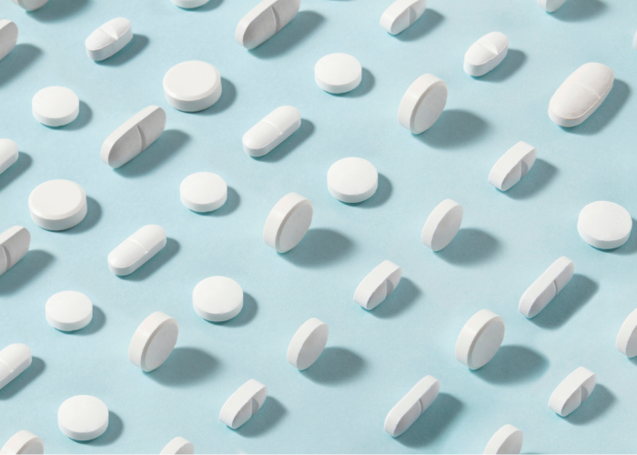 White pills arrangement on soft blue background.