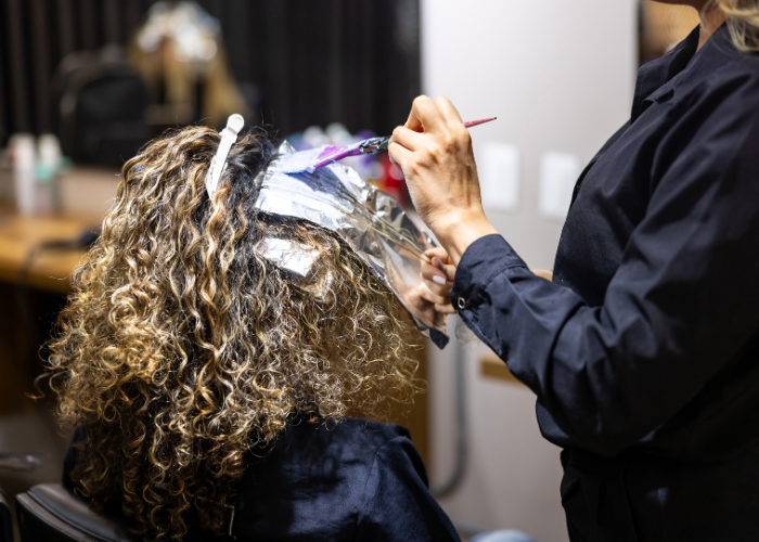 Hairstylist dyeing hair.