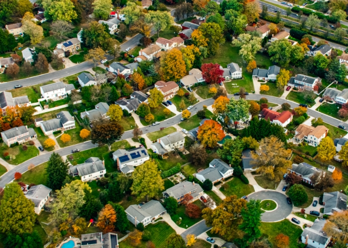 Aerial shot of residential houses in a neighborhood with fall foliage