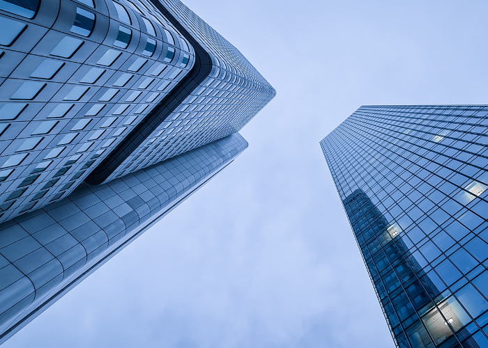 Looking up at skyscrapers with darker blue sky.