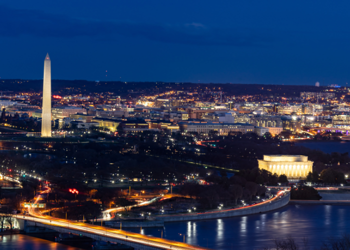 Skyline of Washington DC at night with city lit up.