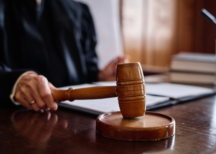 Judge in courtroom knocking gavel.
