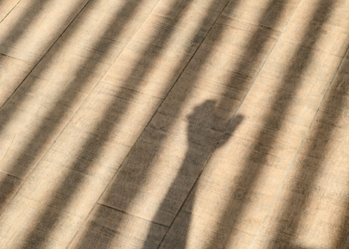 Shadow of hand holding prison bar for article: Children the Law Incorrectly Calls Prisoners