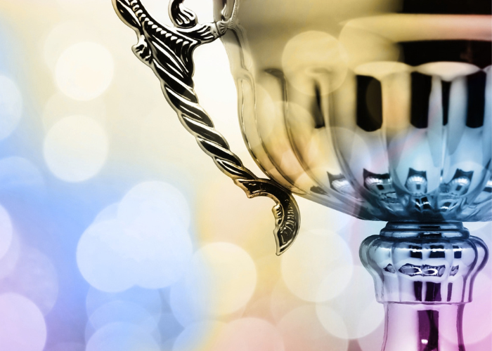 Gold trophy surrounded by colorful lights.